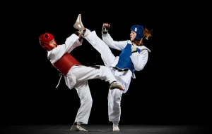 2 young taekwondo practitioners participating in a tournament. Highlights the competitive benefits of martial arts for kids